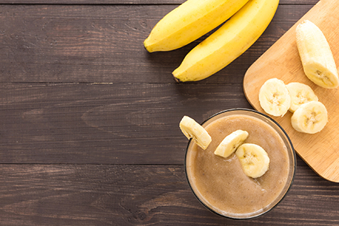Banana smoothie on wooden background. Top view