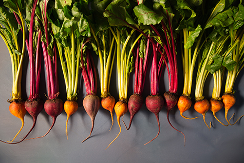 Mix of red and gold beets on grey background. Food background. Concept of healthy eating