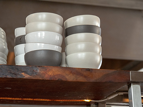 Stack of black and white ceramic bowls sitting on a restaurant shelf