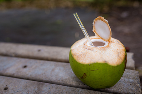 Freshly opened coconut drink with straw