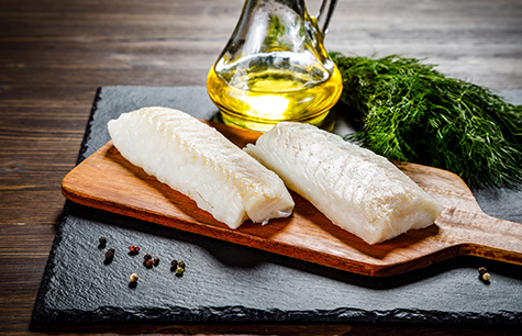 Fresh raw cod fillet on cutting board
