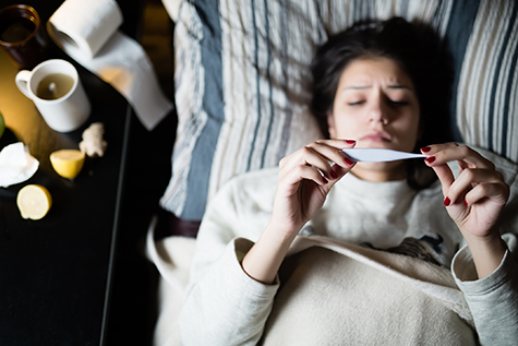 Flu.Woman Caught Cold.Virus.Sick woman laying in bed under wool blanket