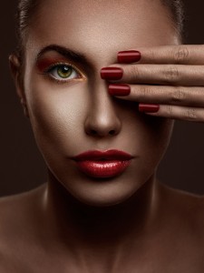 Woman's face with elegant make-up and manicured nails