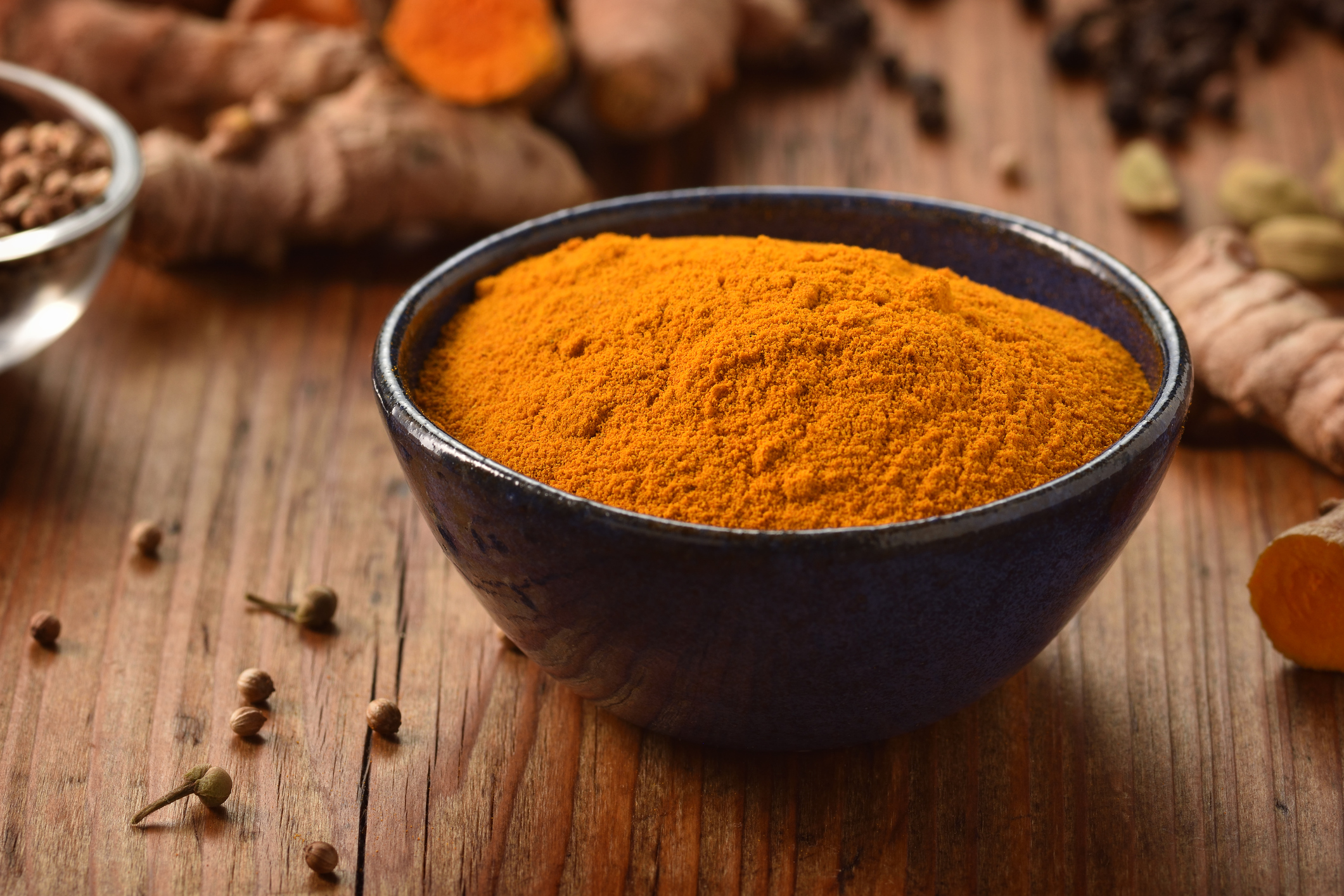 Tumeric in a bowl on wooden background.