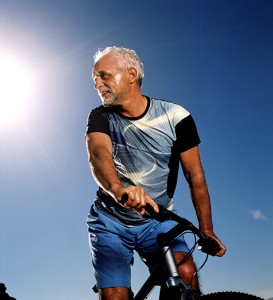 Low angle view of an elderly man cycling