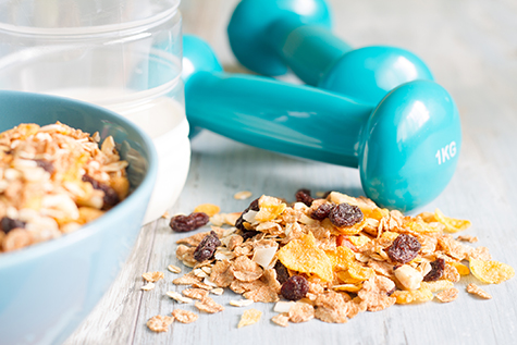 Diet and fitness concept with dumbbells and muesli