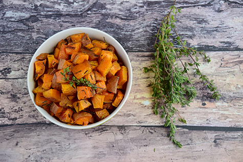 Bowl of roasted cubed sweet potato with thyme