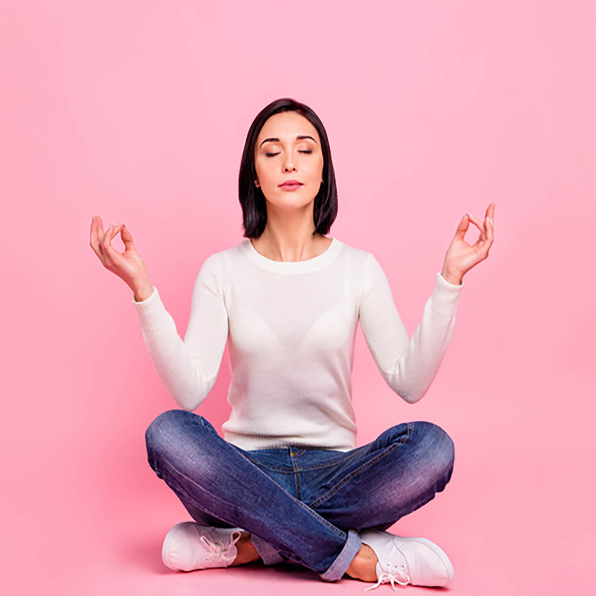 Full length photo of charming lady sitting on floor relaxed on yoga lotus position wear white pullover and jeans isolated pink color background