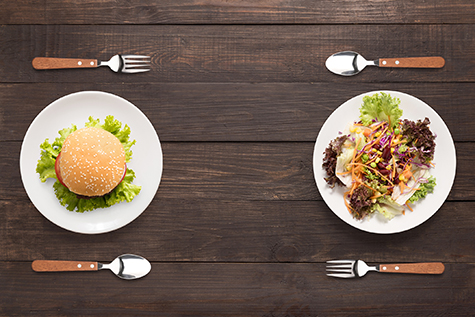 Fresh salad and burger on the wooden background. contrasting foo