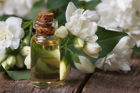 bottle of fragrant jasmine essence closeup and flowers