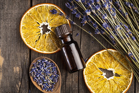 Essential oil lavender and orange dry on a wooden table, top view