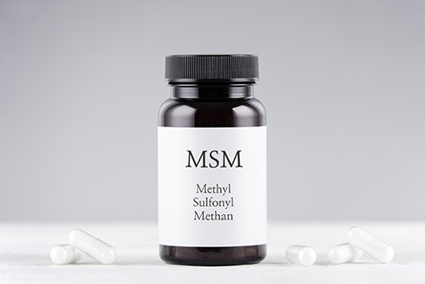 nutritional supplement msm, sulfur, methylsulfonylmethan bottle and capsules on gray