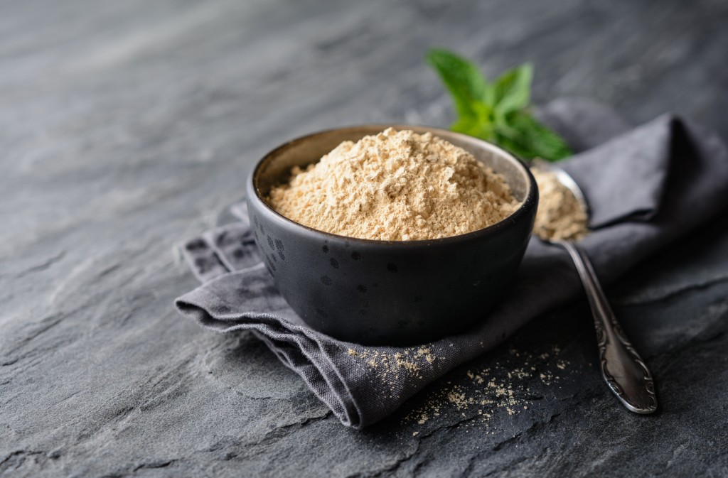 Dietary supplement, Maca root powder in a bowl and spoon with copy space