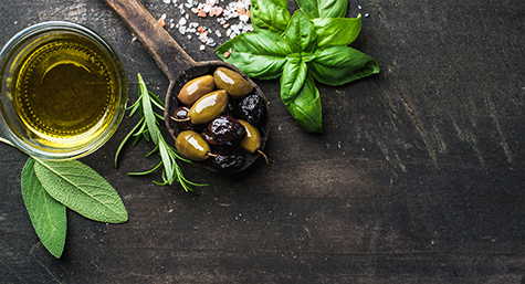 Green and black Mediterranean olives in old cooking spoon