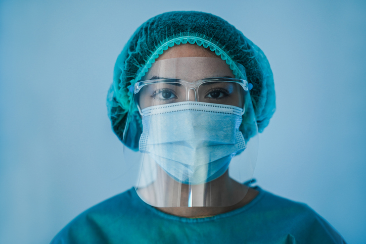 Portrait of young female nurse work inside hospital during coronavirus period - Woman medical worker on Covid-19 outbreak wearing face protective mask