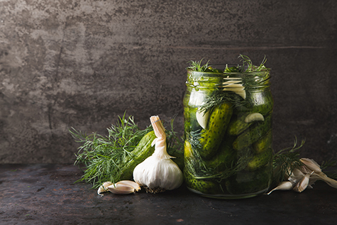 Glass jar of pickles with dill and garlic