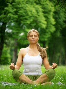 Woman sitting in yoga pose meditation outdoors