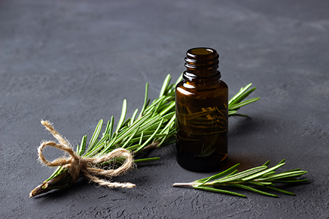 A bottle of essential oil with rosemary