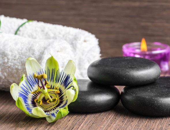 beautiful spa concept of passiflora flower, black zen stones