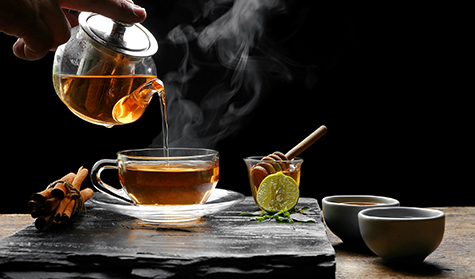Pouring herbal hot tea with glass tea set