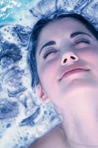 portrait of beautiful woman immersing her hair in water
