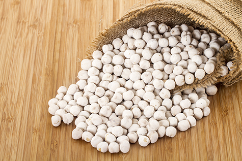 white roasted chickpeas in a bowl on wood background