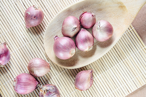 Shallots on a wooden ladle