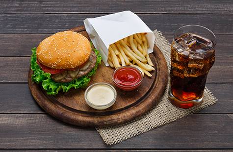 Fast food take away. Hamburger, cola and fries on wood