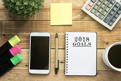 New Year 2018 Goals list written on a notepad