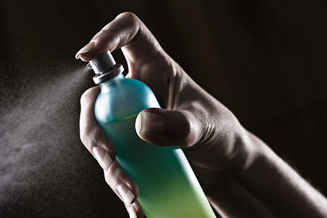 Woman spraying bottle of perfume