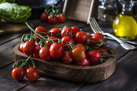 Fresh organic cherry tomatoes shot on rustic wooden table