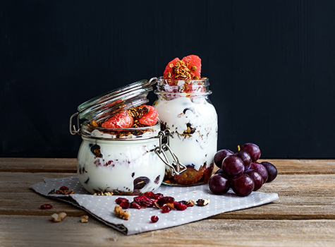 Yogurt and oat granola with grapes, pomegranate, grapefruit in tall