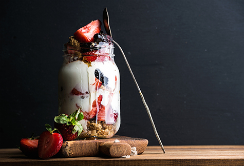 Yogurt oat granola with strawberries, mulberries, honey and mint leaves